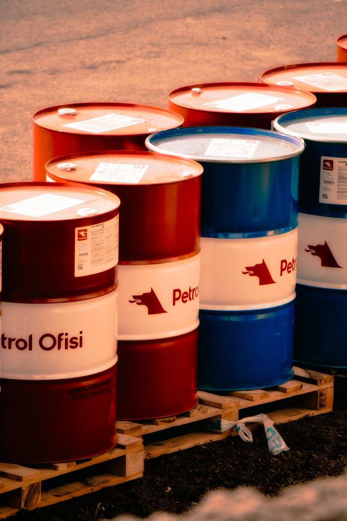 Home A collection of red and blue oil barrels labeled 'Petrol Ofisi' in an outdoor industrial setting in Turkey.